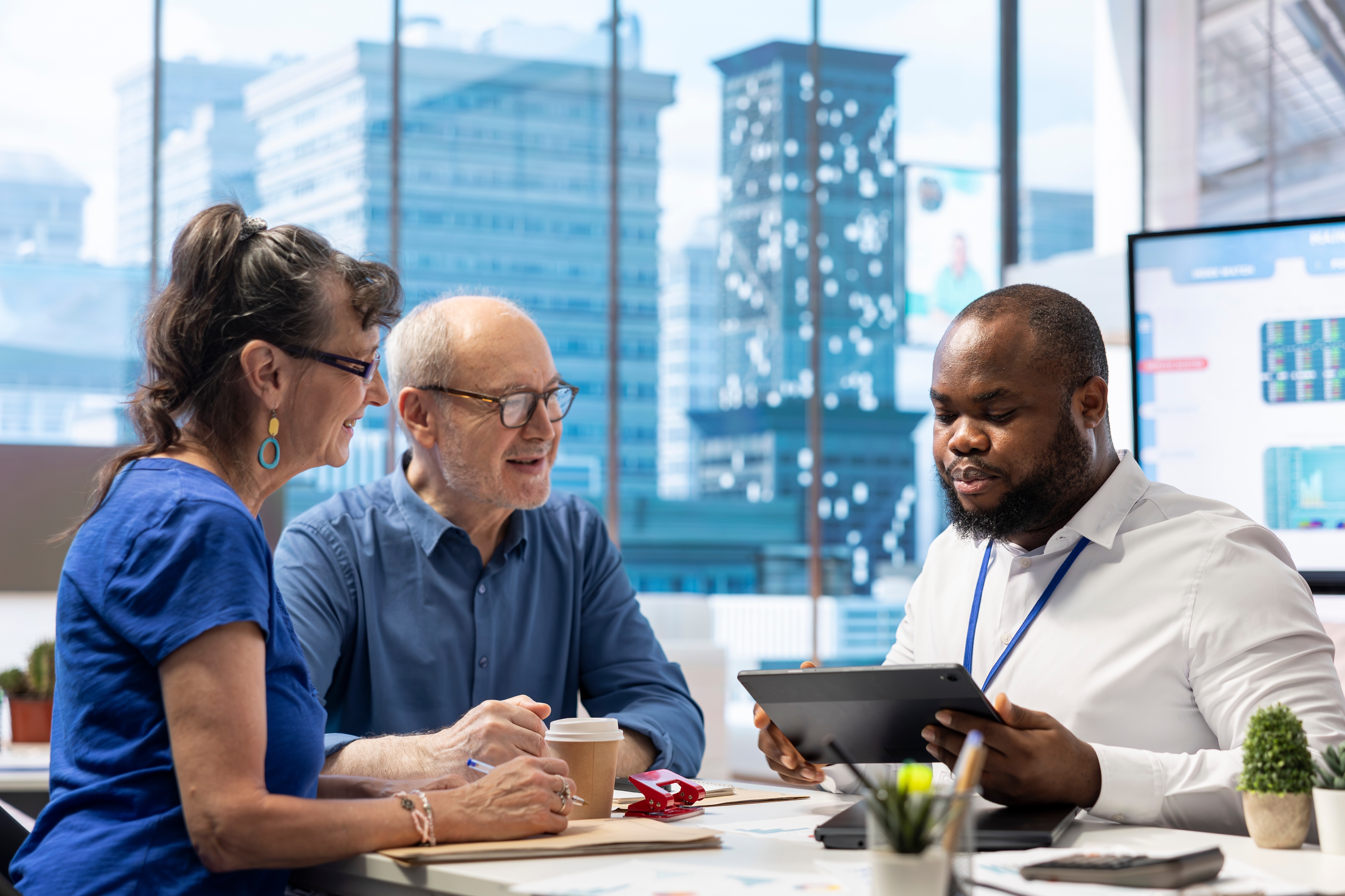 Divers group of people discussing business, looking at a tablet