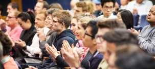 Image of audience clapping at the end of a lecture