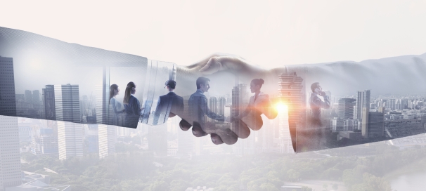 hands shaking on a background of high rise buildings and other men and women shaking hands