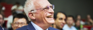 Image of Nobel Laureate Sir Oliver Hart from the inaugural lecture series bearing his name, sat in the audience, smiling