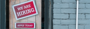 vacancy signs hanging off door, signs say "we are hiring, apply today"