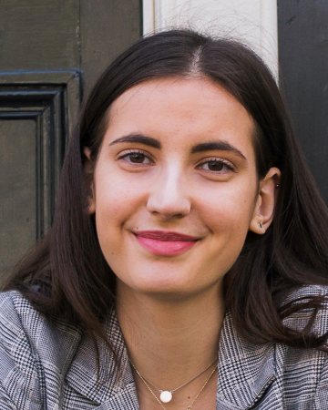 Profile photo of Karolin Lehmann, white female with long dark hair, sitting on steps