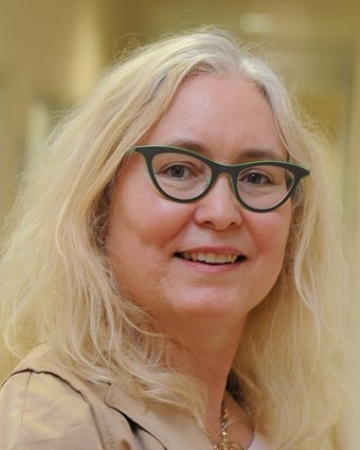 Photo of Professor Renee B Adams, white blonde female wearing gray-green frames