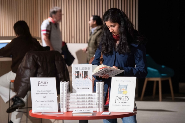 Lady browsing book stand with Jon Danielsson's book The Illusion of Control