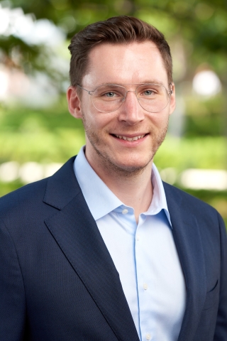 Profile photo of Dr Constantin Charles, white caucasian male, dark blond hair with blue eyes and wearing light coloured frames