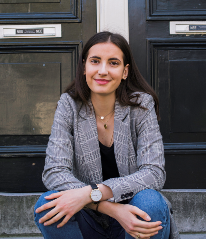 Profile photo of Karolin Lehmann, white female with long dark hair, sitting on steps