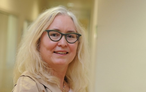 Photo of Professor Renee B Adams, white blonde female wearing gray-green frames