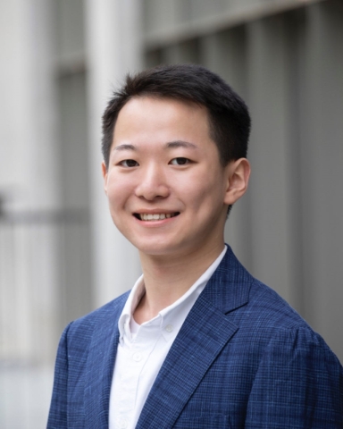 Portrait of Ronan Ding, FMG RA, Asian man, dark hair, wearing a navy jacket on top of a white shirt